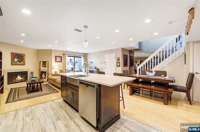 kitchen featuring a warm lit fireplace, recessed lighting, a sink, visible vents, and stainless steel dishwasher