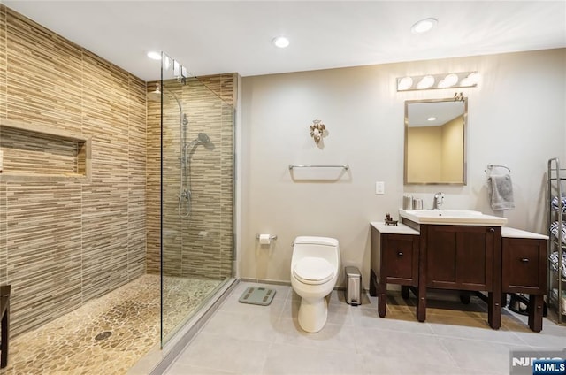 full bath with vanity, a tile shower, toilet, and tile patterned floors