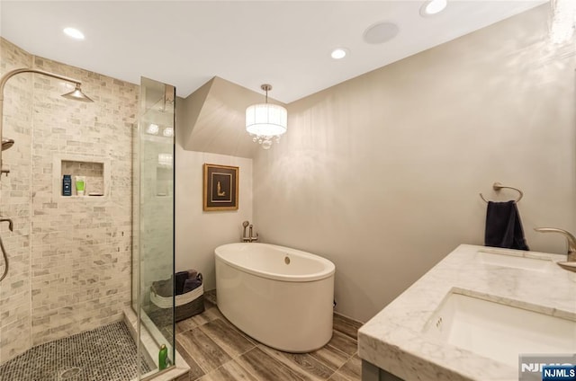 full bath with a soaking tub, a shower stall, wood tiled floor, and a sink