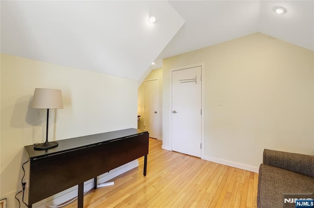 interior space featuring recessed lighting, baseboards, vaulted ceiling, and light wood finished floors