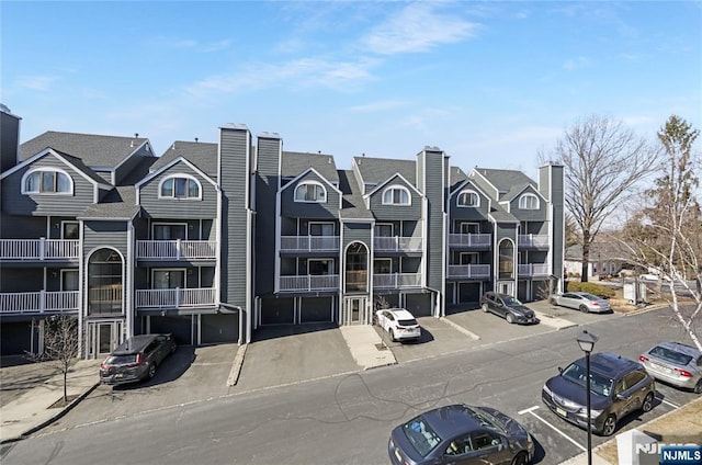 view of building exterior with a residential view and uncovered parking