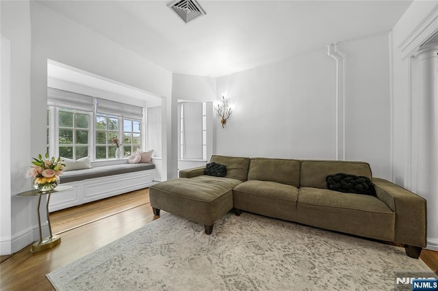 living area featuring wood finished floors, visible vents, and baseboards