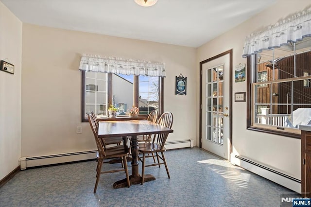 carpeted dining area featuring a baseboard heating unit