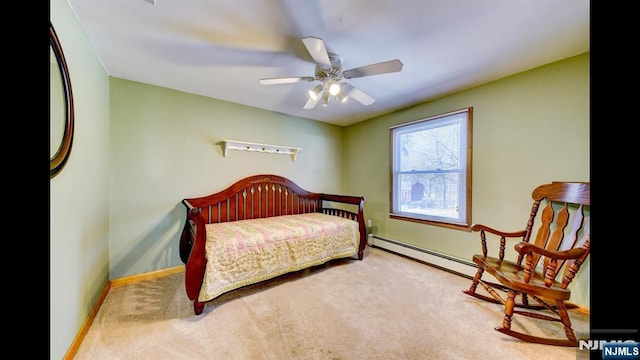 carpeted bedroom featuring black refrigerator, baseboard heating, ceiling fan, and baseboards