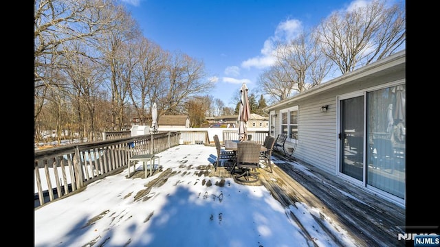 snow covered deck featuring outdoor dining space