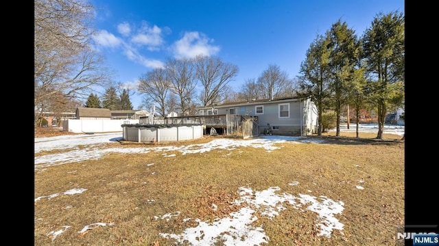 snow covered back of property featuring crawl space and a fenced in pool