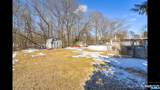 yard covered in snow with a storage unit and an outbuilding