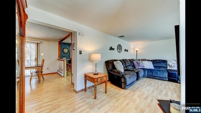 living room with light wood-style floors, baseboards, visible vents, and baseboard heating