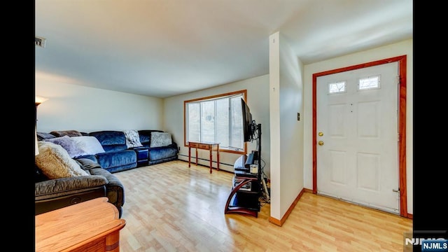 entryway featuring a baseboard heating unit, light wood-type flooring, and baseboards