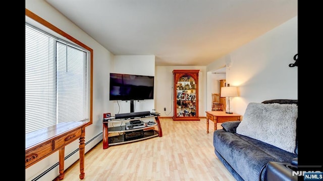 living room with light wood-style floors and a baseboard heating unit