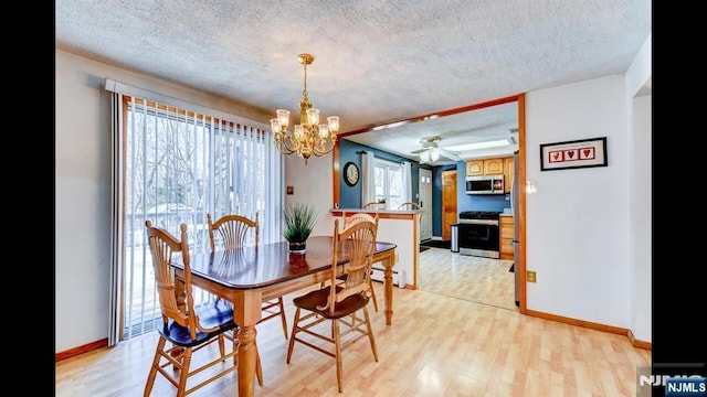 dining area featuring light wood finished floors, baseboards, and a textured ceiling