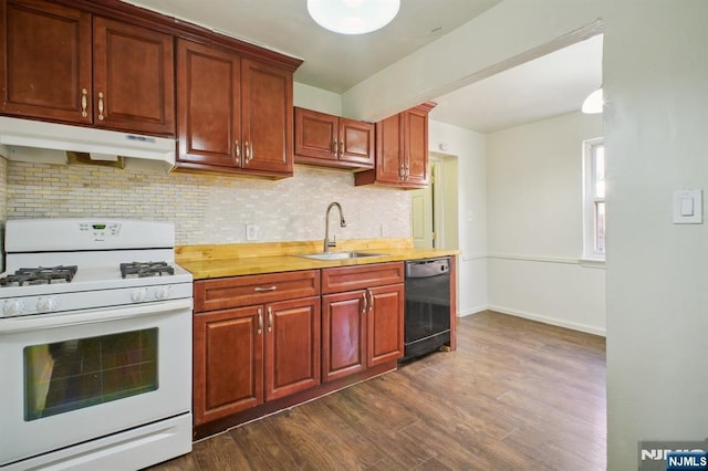 kitchen featuring black dishwasher, white range with gas cooktop, light countertops, under cabinet range hood, and a sink