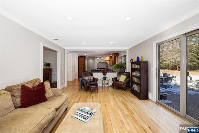 living room with ornamental molding, recessed lighting, visible vents, and light wood-style floors