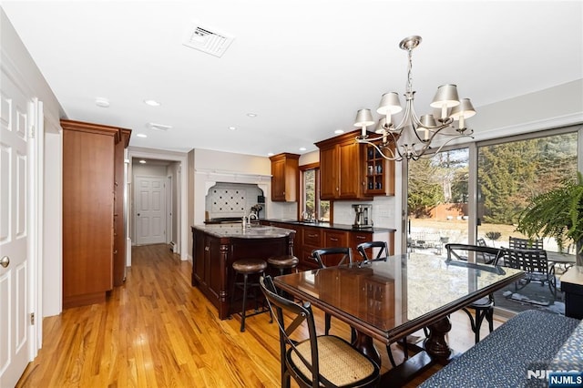 dining space featuring light wood-style floors, recessed lighting, visible vents, and an inviting chandelier