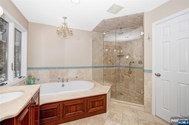 bathroom with a stall shower, a bath, and vanity