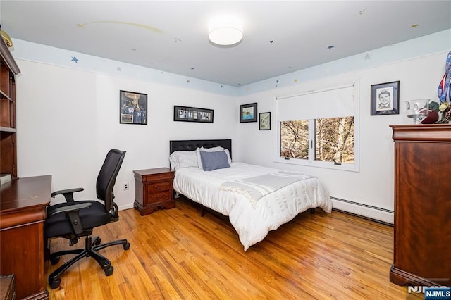 bedroom with light wood-style flooring and a baseboard heating unit