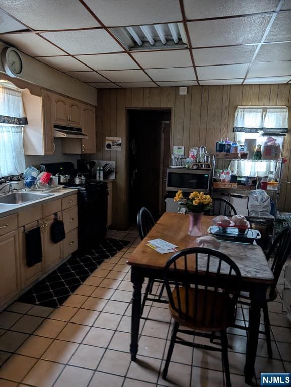 kitchen featuring sink, a drop ceiling, light tile patterned flooring, black electric range oven, and light brown cabinets