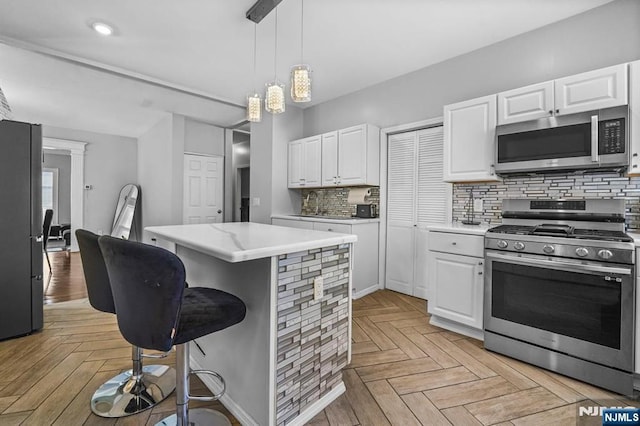 kitchen featuring appliances with stainless steel finishes, light parquet flooring, and white cabinets