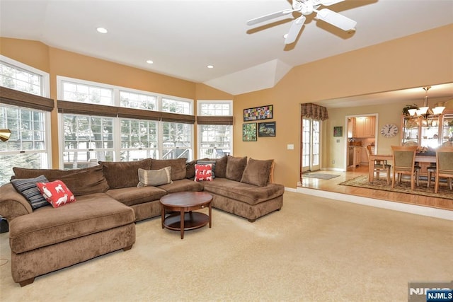 carpeted living area featuring a wealth of natural light, ceiling fan with notable chandelier, recessed lighting, and vaulted ceiling