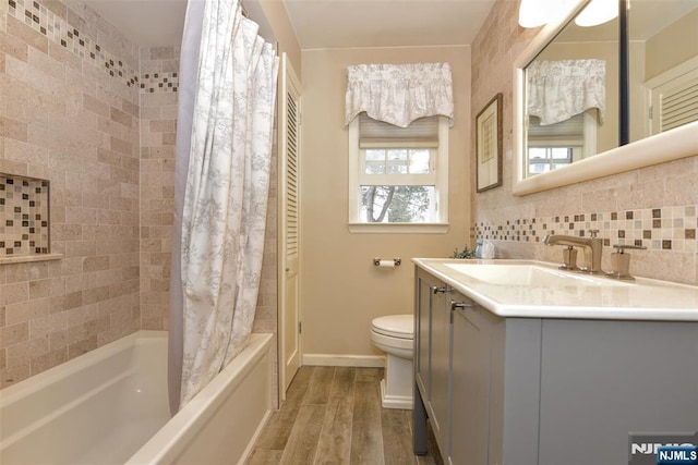 bathroom with backsplash, baseboards, toilet, wood finished floors, and shower / bathtub combination with curtain