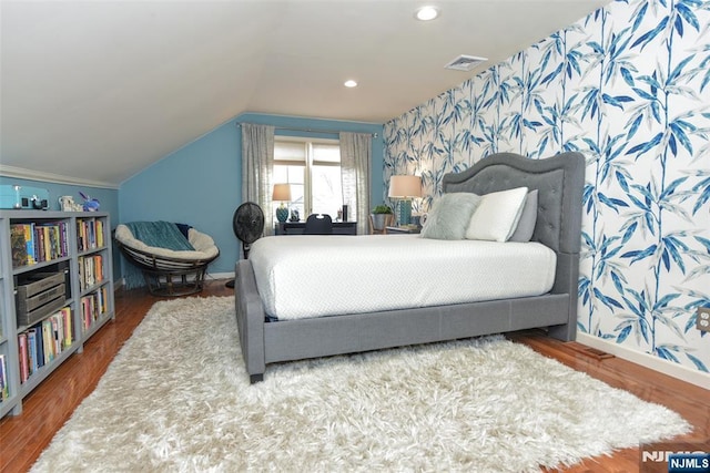 bedroom featuring visible vents, wood finished floors, recessed lighting, wallpapered walls, and vaulted ceiling