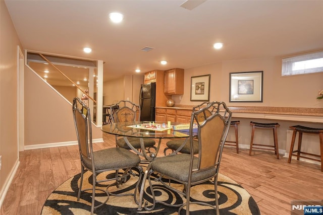 dining space with light wood finished floors, visible vents, and recessed lighting