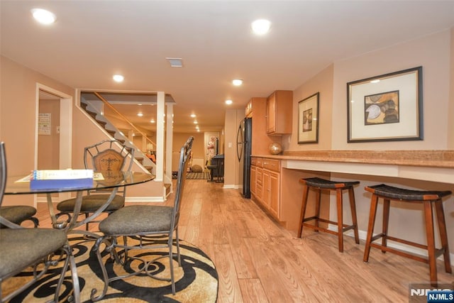 dining area with stairway, recessed lighting, light wood-type flooring, and baseboards