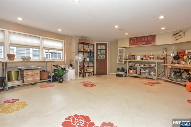 misc room featuring finished concrete floors, recessed lighting, and a workshop area