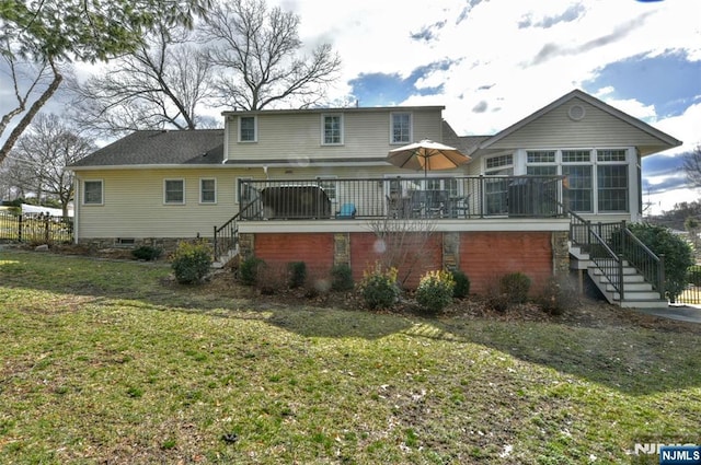 rear view of property featuring stairway, a yard, and a sunroom