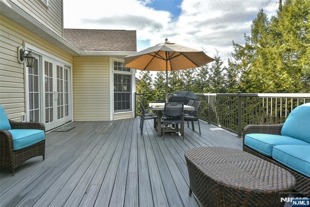 wooden deck featuring outdoor dining space, french doors, and an outdoor hangout area