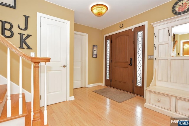 entrance foyer featuring stairs, baseboards, and light wood finished floors