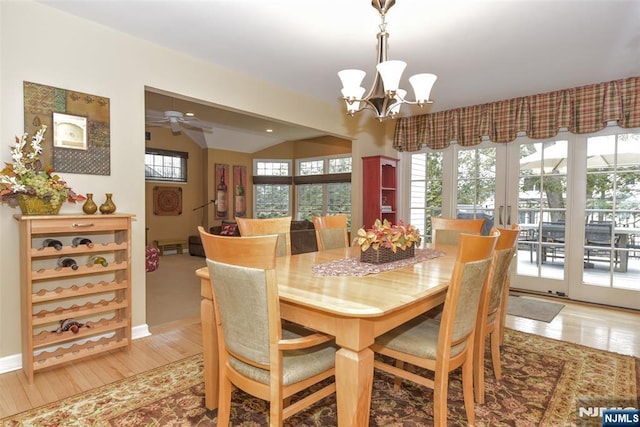 dining room featuring a healthy amount of sunlight, french doors, light wood-style floors, and lofted ceiling