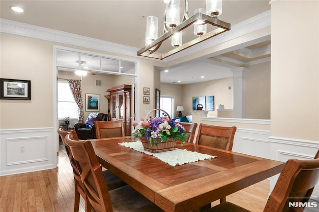 dining area with ornate columns, light hardwood / wood-style flooring, and crown molding