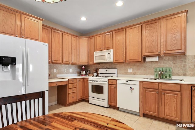 kitchen featuring sink, light tile patterned flooring, white appliances, and backsplash