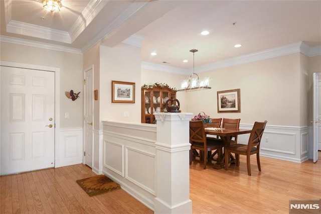 dining room with crown molding, a chandelier, and light hardwood / wood-style floors