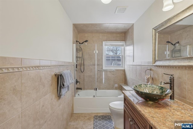 full bathroom featuring tile walls, shower / bath combination with glass door, tile patterned flooring, and vanity