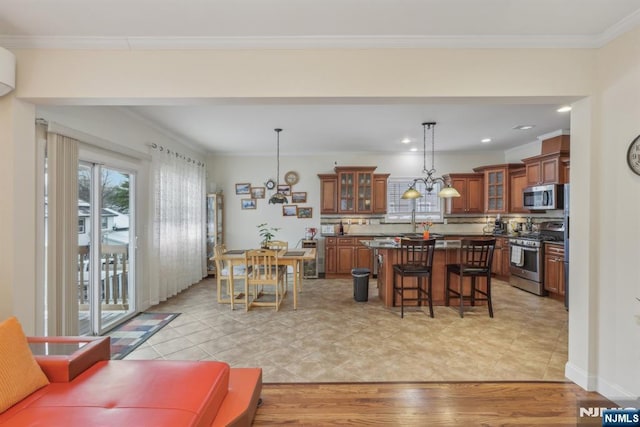 dining space with light tile patterned flooring, an inviting chandelier, and crown molding