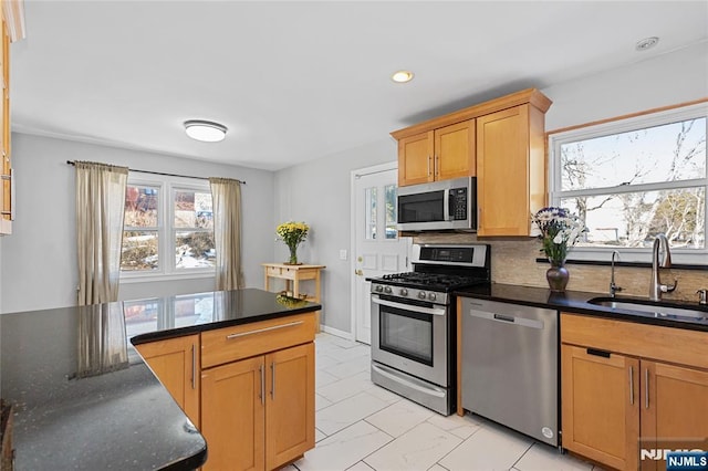 kitchen with decorative backsplash, sink, stainless steel appliances, and dark stone counters