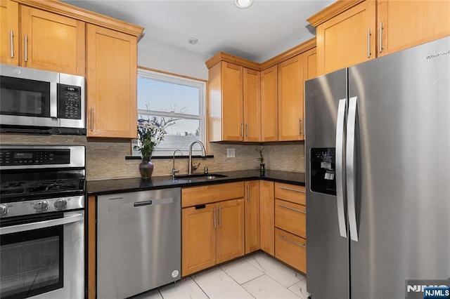 kitchen featuring appliances with stainless steel finishes, decorative backsplash, and sink