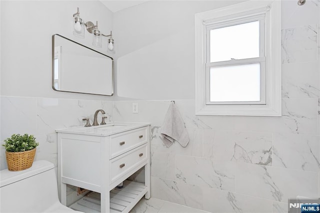 bathroom featuring vanity, tile walls, and toilet