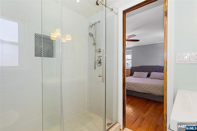 bathroom with hardwood / wood-style flooring, ceiling fan, and walk in shower