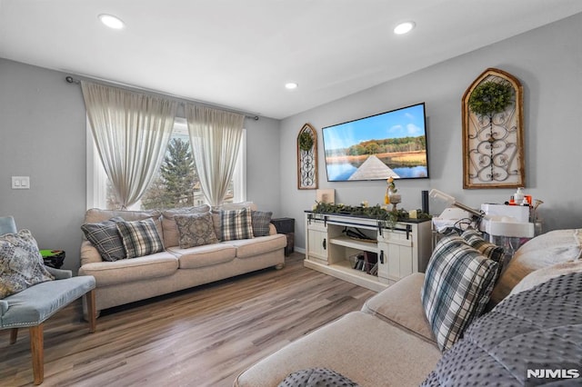 living room with recessed lighting, baseboards, and wood finished floors