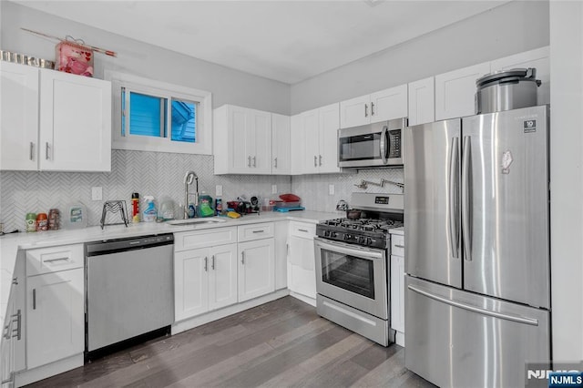 kitchen featuring appliances with stainless steel finishes, decorative backsplash, sink, and white cabinets