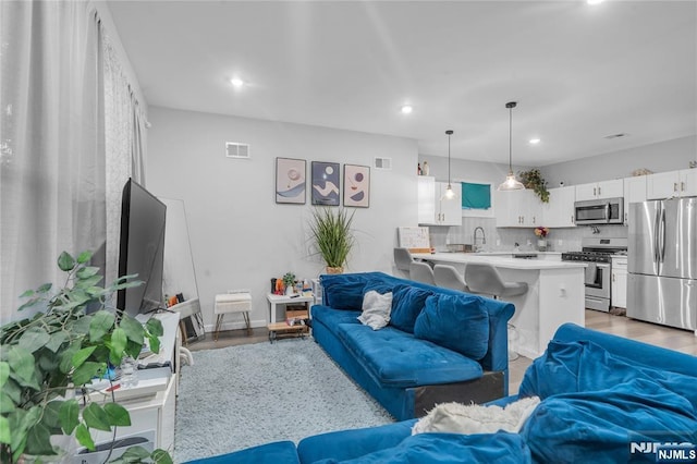 living room featuring light wood-type flooring and sink