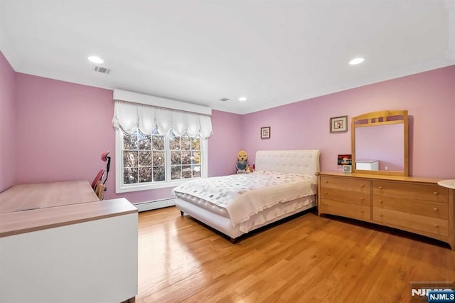 bedroom featuring light hardwood / wood-style floors and a baseboard radiator