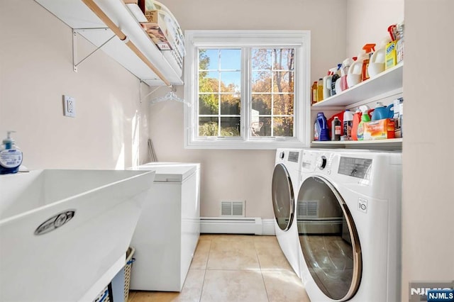 laundry room featuring independent washer and dryer, light tile patterned floors, sink, and a baseboard heating unit