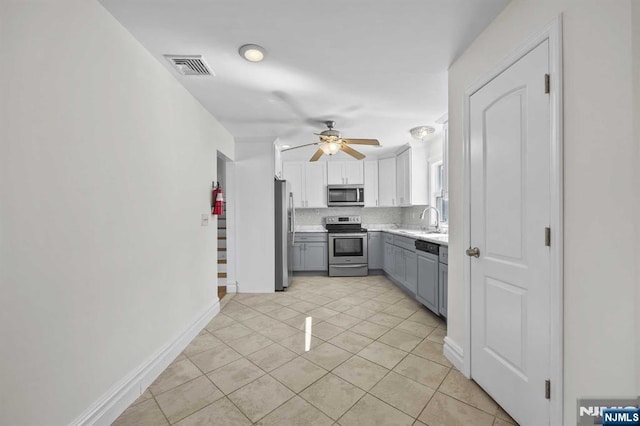 kitchen with visible vents, appliances with stainless steel finishes, gray cabinets, light countertops, and backsplash