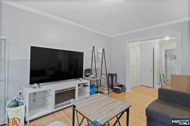 living area with ornamental molding and wood finished floors