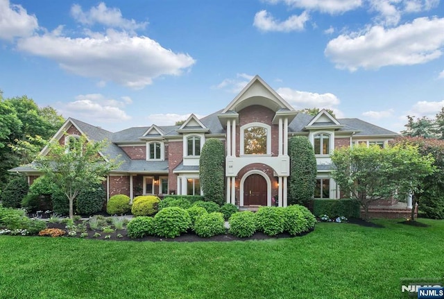 view of front facade with a front yard and brick siding