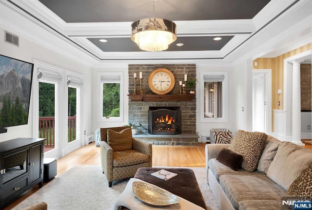 living room with coffered ceiling, a fireplace, wood finished floors, visible vents, and ornamental molding